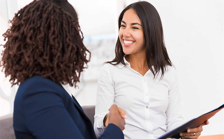 Mulher sorri para colega de trabalho