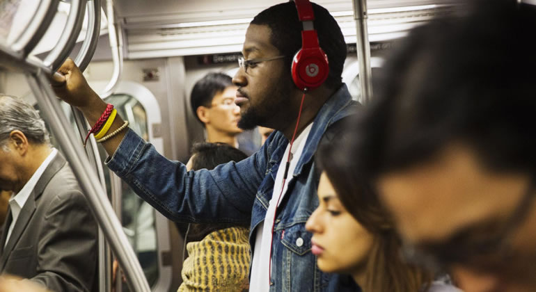 Homem com fone de ouvido no metrô